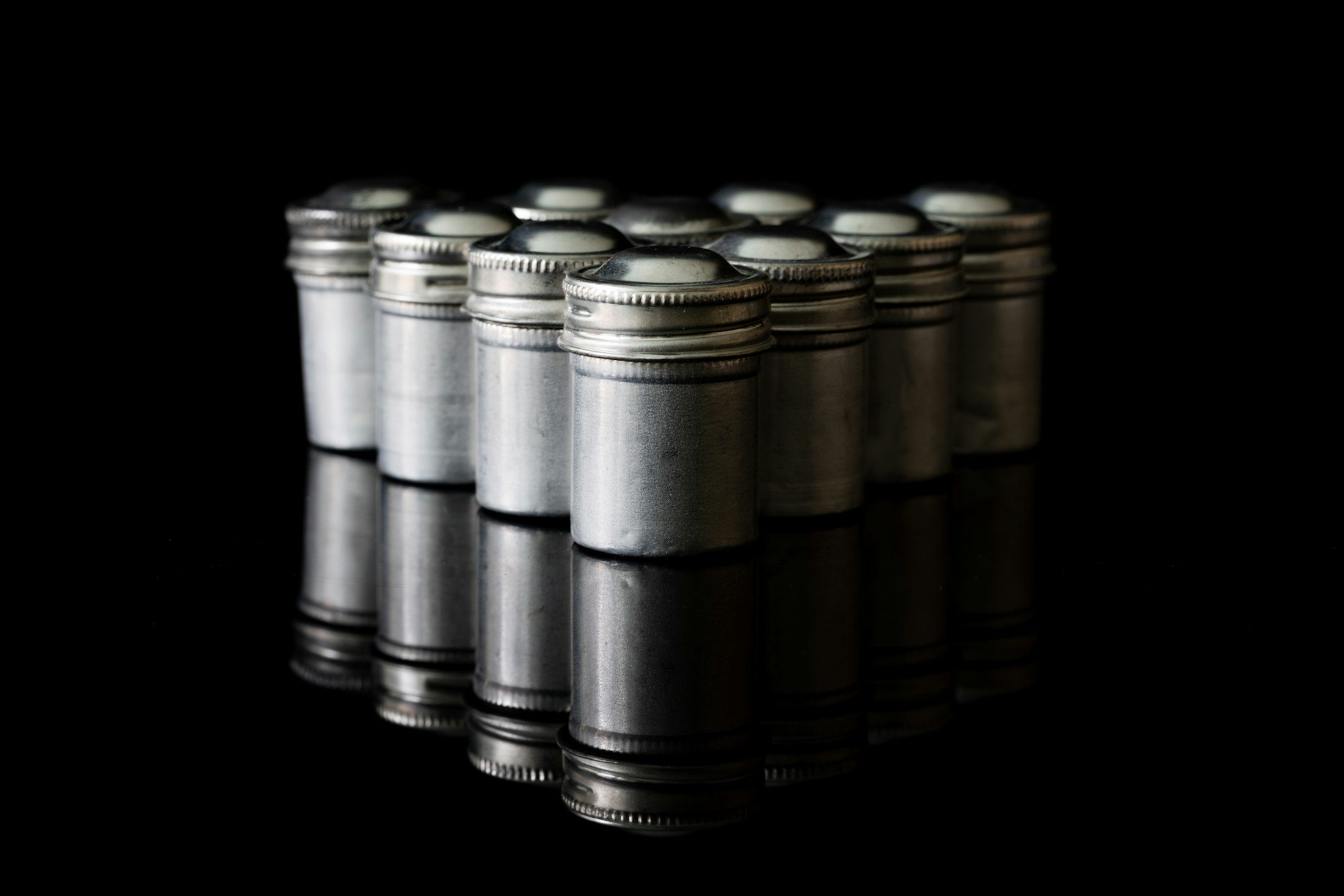 Latas de aluminio sin etiqueta sobre una superficie negra